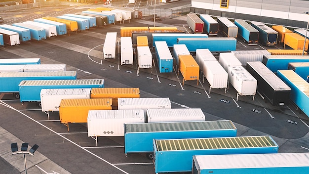 Aerial view of large warehouses of goods a logistics center and many parked containers and trailers with cargo logistics warehouses in the industrial areas of the city