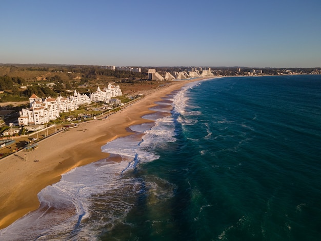 Aerial view of modern white buildings next to a lonely beach at algarrobo chile