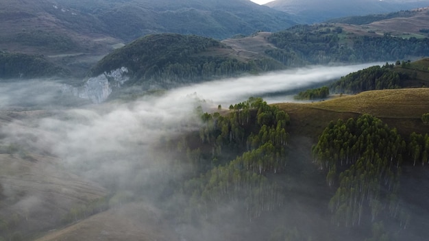 Aerial view of morning landscape with fog and hills in Dumesti village in Apuseni mountains of Romania.