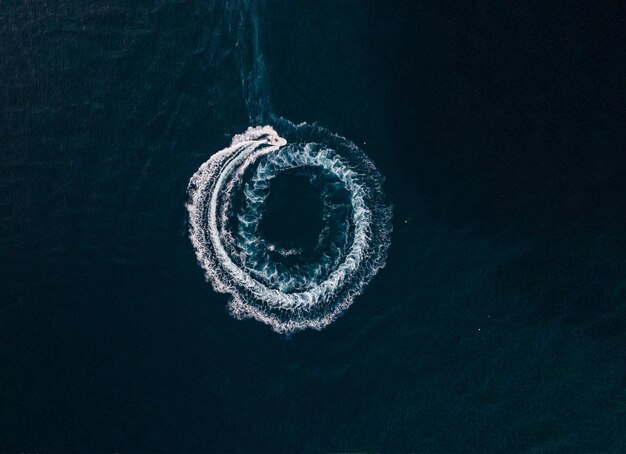 Aerial view of a motorboat sailing on the sea and making splashes