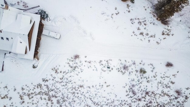 Aerial view of the mountain house covered in snow in the Winter.