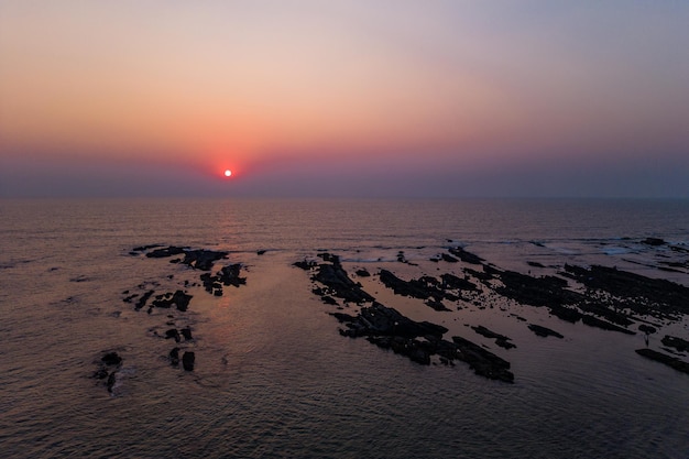 Aerial view of mountain peak and sea and sunset colorful sky from above from drone