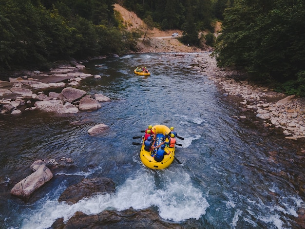 Aerial view of mountain river people rafting in creek. extreme vitality