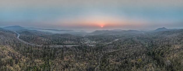 Aerial view of the mountain road the street from above through a misty forest