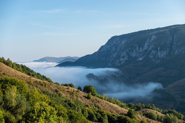 Aerial view of mountain valley covered in clouds in Trascau mountains of Romania