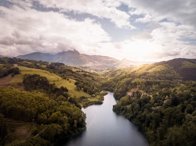 Aerial view of a mountainous river with a road on the edge. Mountain landscape with river