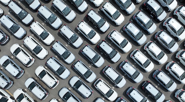 Aerial view of new cars stock at factory parking lot Above view cars parked in a row Automotive