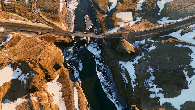 Aerial view of nordic canyon with river flow and snowy mountains creating amazing icelandic scenery. Beautiful fjadrargljufur canyon with stream in iceland, natural landscape. Slow motion.