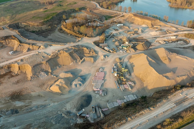 Aerial view of open pit mine of sandstone materials for construction industry with excavators and dump trucks Heavy equipment in mining and production of useful minerals concept