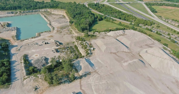 Aerial view in Open pit stone extraction in the canyon with deep green lake