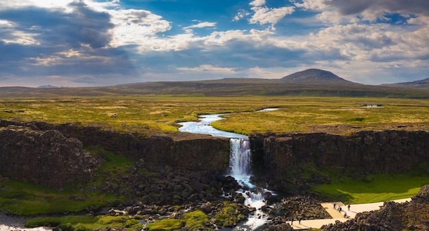 Aerial view of the Oxarafoss waterfall with tourists in Iceland