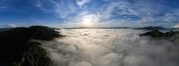 Aerial view Panorama of flowing fog waves on mountain tropical rainforestBird eye view image over the clouds Amazing nature background with clouds and mountain peaks in Thailand