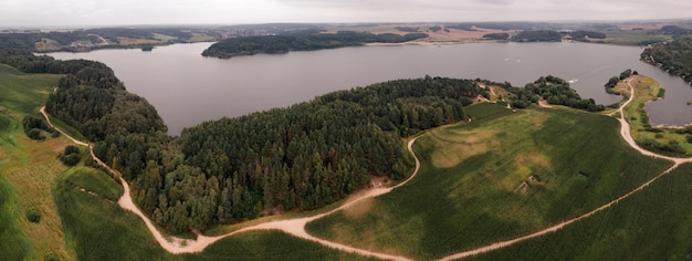 Aerial view panorama of green summer forest corn fields and blue lake Rural landscape