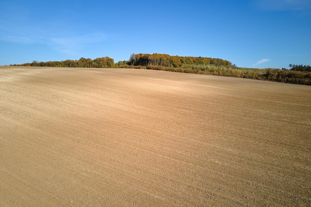 Aerial view of plowed agricultural field with cultivated fertile soil prepared for planting crops in spring