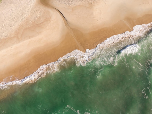 Aerial view of Prainha Beach, a paradise in the west side of Rio de Janeiro, Brazil. Greenish sea waves and sand. Top view. Sunny day at dawn. Drone Photo.