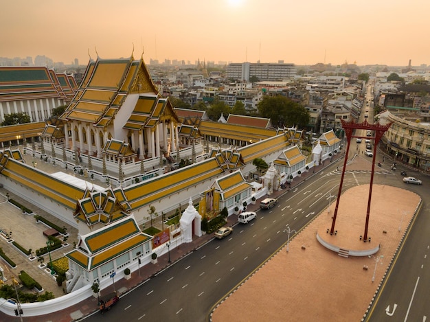 An aerial view of Red Giant Swing and Suthat Thepwararam Temple at sunset scene The most famous tourist attraction in Bangkok Thailand