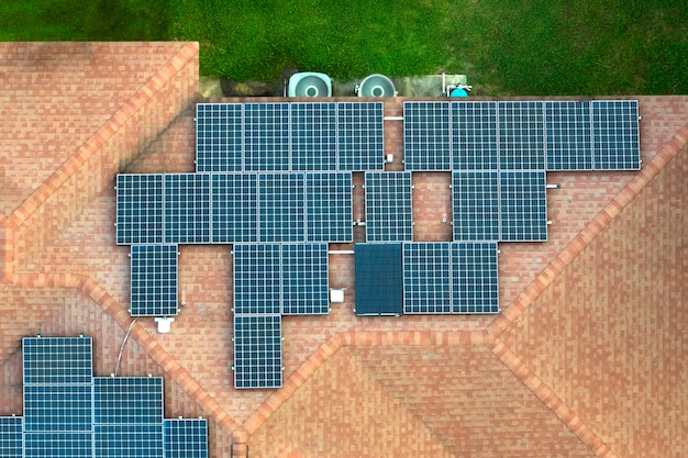 Aerial view of regular american home roof with blue solar photovoltaic panels for producing clean ecological electric energy Investing in renewable electricity for retirement income