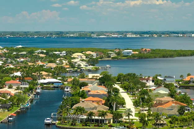 Aerial view of residential suburbs with one storey houses located near wildlife wetlands with green tropical vegetation on sea shore Living close to nature in warm climate concept