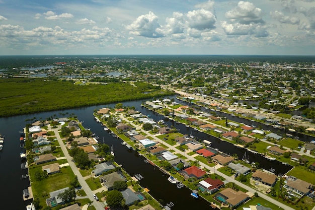 Aerial view of residential suburbs with one storey houses located near wildlife wetlands with green tropical vegetation on sea shore Living close to nature in warm climate concept