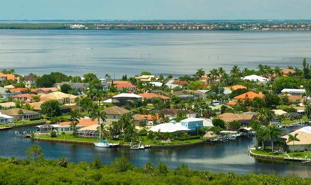 Aerial view of residential suburbs with one storey houses located near wildlife wetlands with green tropical vegetation on sea shore Living close to nature in warm climate concept