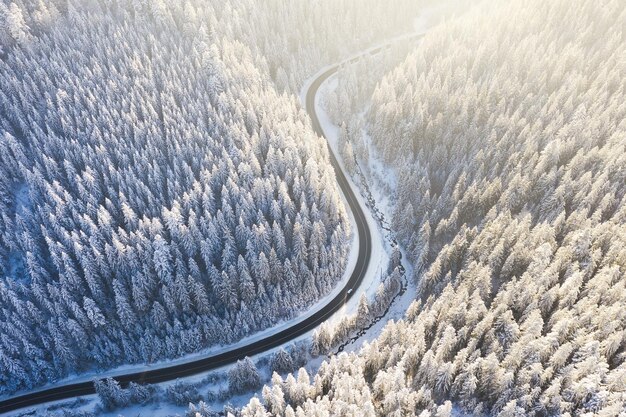 Aerial view on the road and forest at the winter time Natural winter landscape from air Fores