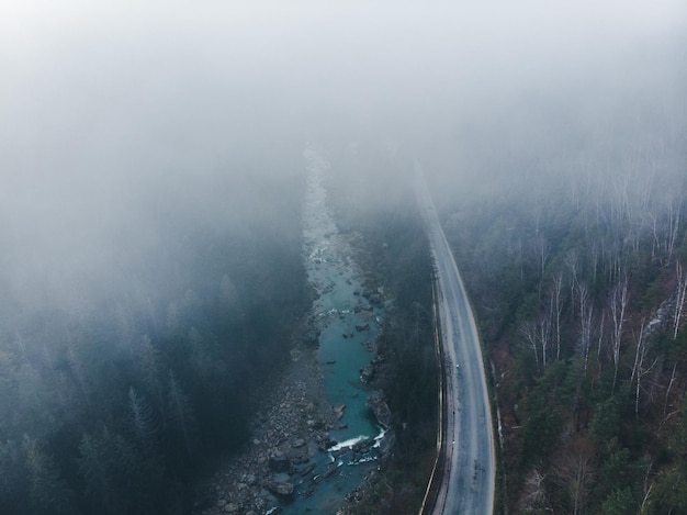 Aerial view of road in mountains fog covered the forest