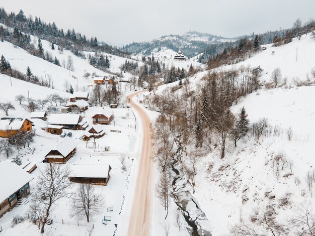 Aerial view of the road in snowed village in the middle of carpathian mountains travel ukraine