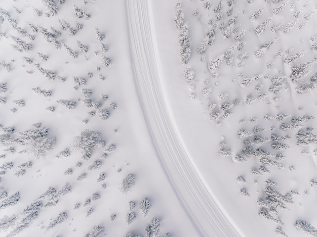 Aerial view of the road in the winter snow forest in Finland Lapland