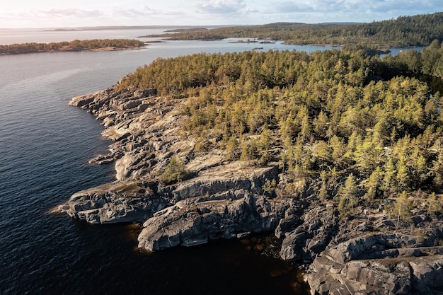 Aerial view of rocky island with jagged coastline overgrown with sparse trees Karelia Russia