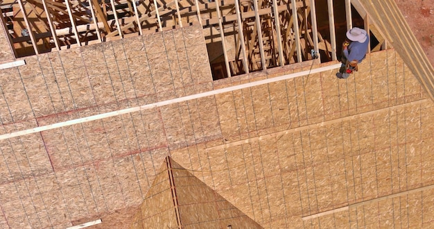 Aerial view of roofing construction with applying into plywood wooden roof frame house