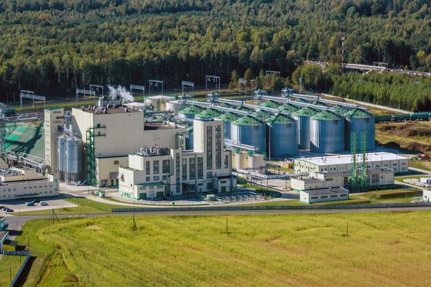 Aerial view on rows of agro silos granary elevator with seeds cleaning line on huge agroprocessing manufacturing plant for processing drying cleaning and storage of agricultural products