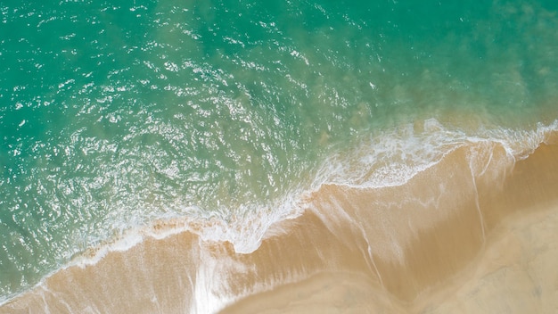 Aerial view sandy beach and crashing waves on sandy shore Beautiful tropical sea in the morning summer season image by Aerial view drone shot high angle view Top down