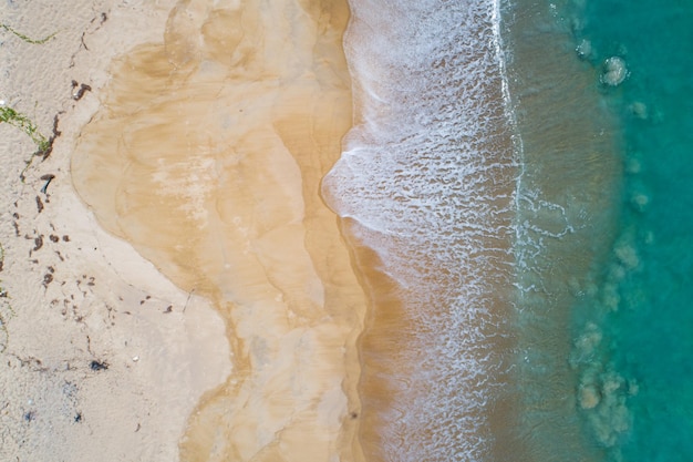 Aerial view sandy beach and crashing waves on sandy shore Beautiful tropical sea in the morning summer season image by Aerial view drone shot high angle view Top down