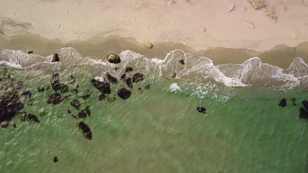 Aerial view of sandy beach and sea waves