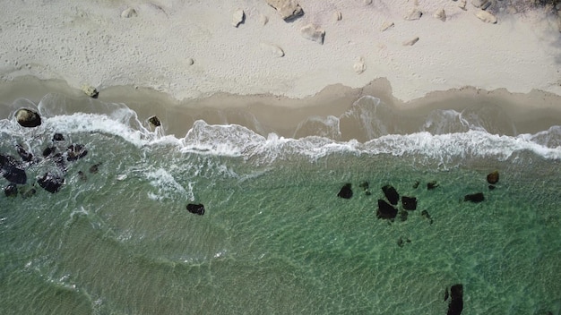 Aerial view of sandy beach and sea waves