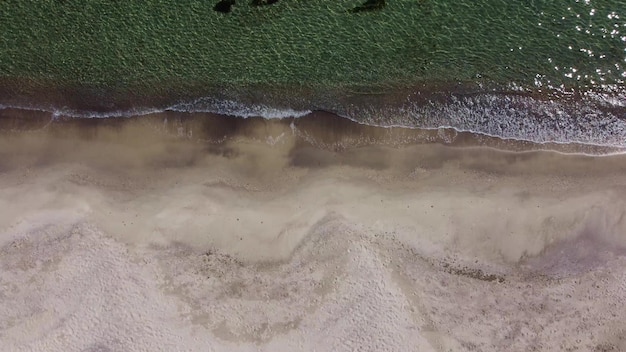 Aerial view of sandy beach and sea waves