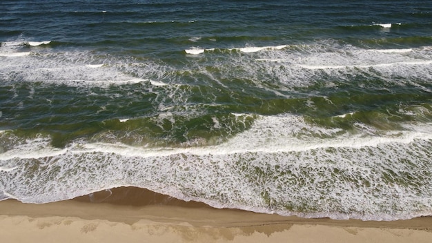 Aerial view of sandy beach and sea waves