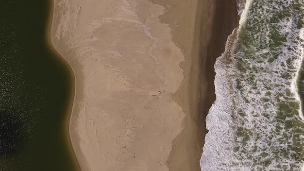 Aerial view of sandy beach and sea waves