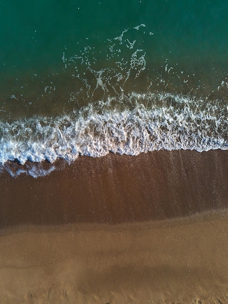 Aerial view of sandy beach and sea with waves Top view