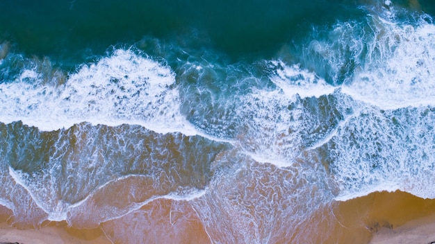 Aerial view sandy beach and waves Beautiful tropical sea in the morning summer season image by Aerial view drone shot high angle view Top down sea waves