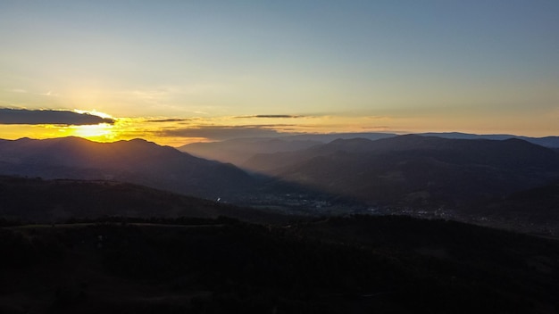 Aerial view over scenic hills landscape at sunset time.