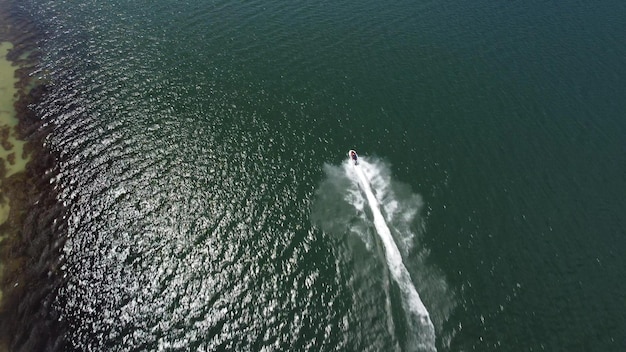 Aerial view of a scooter at the lake surface Luxury floating boat on water at sunny day