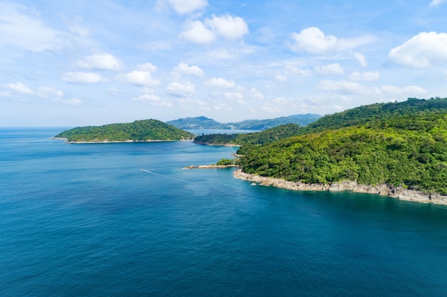 Aerial view on the sea coastline with stones rocks and mountains rainforest. Beautiful natural seascape at the summer day time. View on the west coast of the island of Phuket island Thailand.