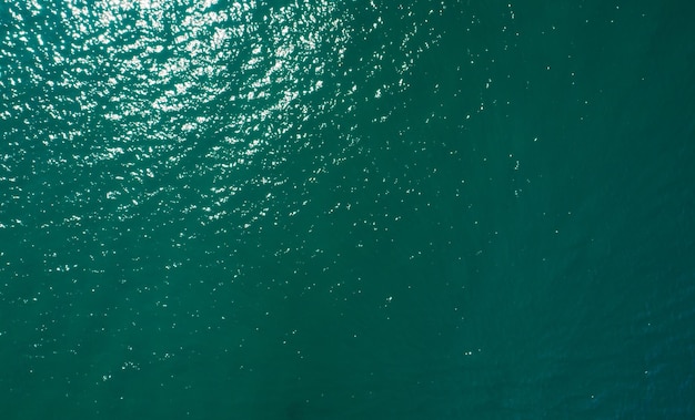 Aerial view of sea surface water texture background and sun reflections Aerial flying drone view Waves water surface texture on sunny tropical ocean in Phuket island Thailand