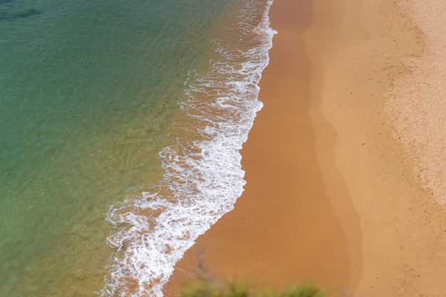 Aerial view of sea waves and sandy beach