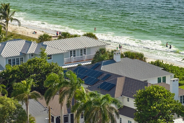 Aerial view of seaside expensive american home roof with blue solar photovoltaic panels for producing clean ecological electric energy Renewable electricity with zero emission concept