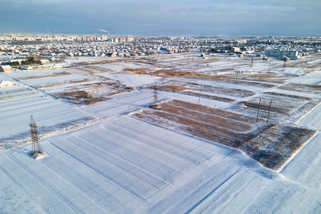 Aerial view of snow covered agricultural fields with barren surface in winter