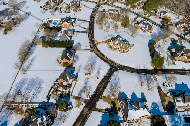 Aerial view of snowy winter day with house roofs covered by white snow