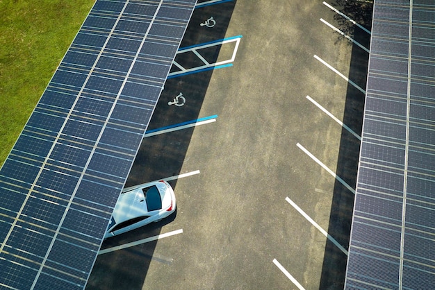 Aerial view of solar panels installed as shade roof over parking lot for parked cars for effective generation of clean electricity Photovoltaic technology integrated in urban infrastructure