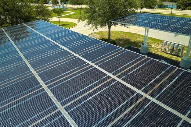 Aerial view of solar panels installed as shade roof over parking lot for parked cars for effective generation of clean electricity Photovoltaic technology integrated in urban infrastructure